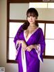 A woman in a purple robe posing for a picture.