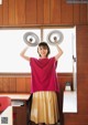 A woman holding two dumbbells over her head in an office.