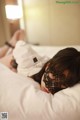 A woman laying on a bed with a mask on her face.