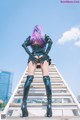 A woman with pink hair standing on a set of stairs.