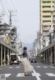 A woman walking across a crosswalk in the middle of a city.