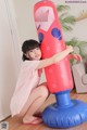 A little girl is playing with an inflatable punching bag.